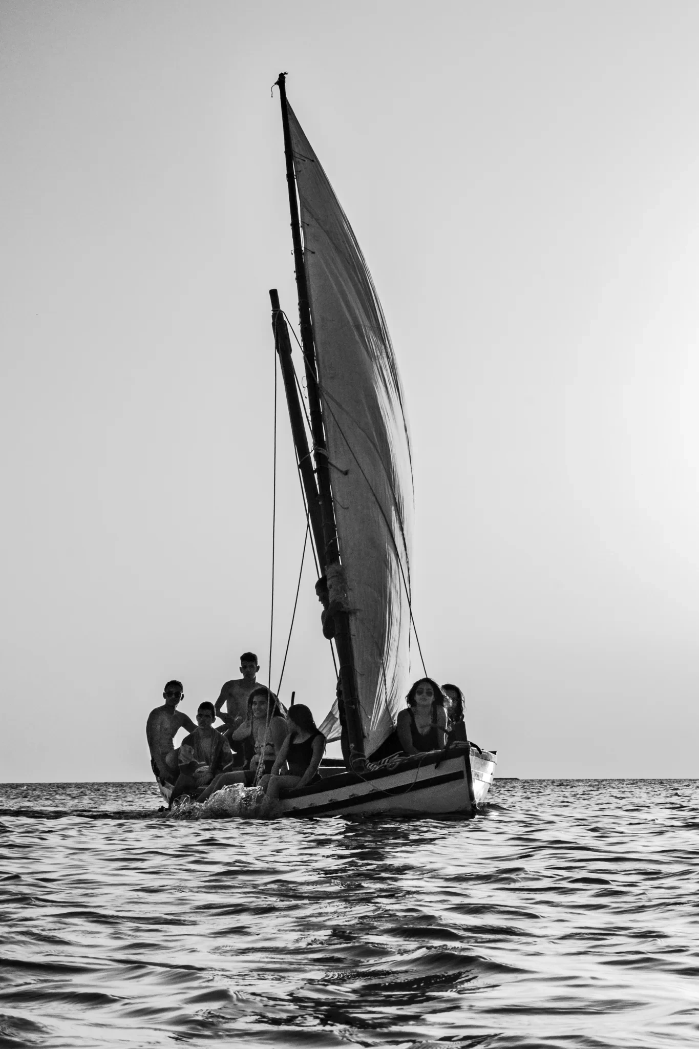 Bateau à voile latine et ses passagers sur la mer