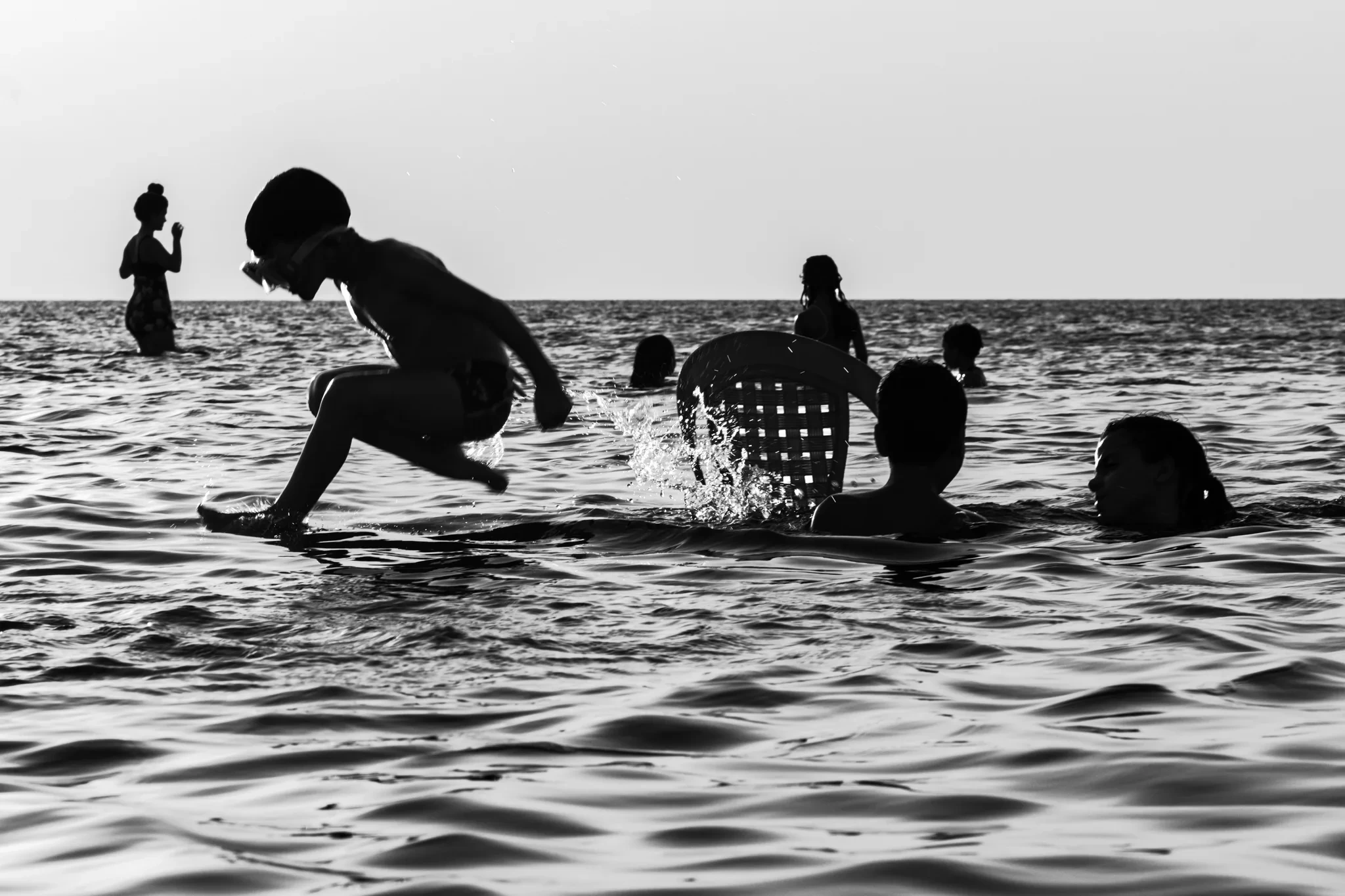 Un enfant éclabousse l’eau près d’autres baigneurs