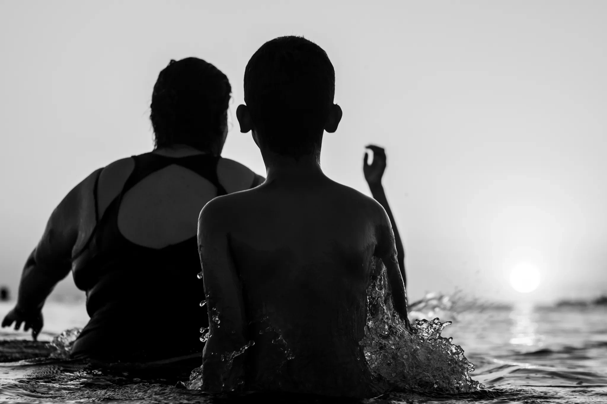 Baigneurs vus de dos, baignés par la lumière du soleil