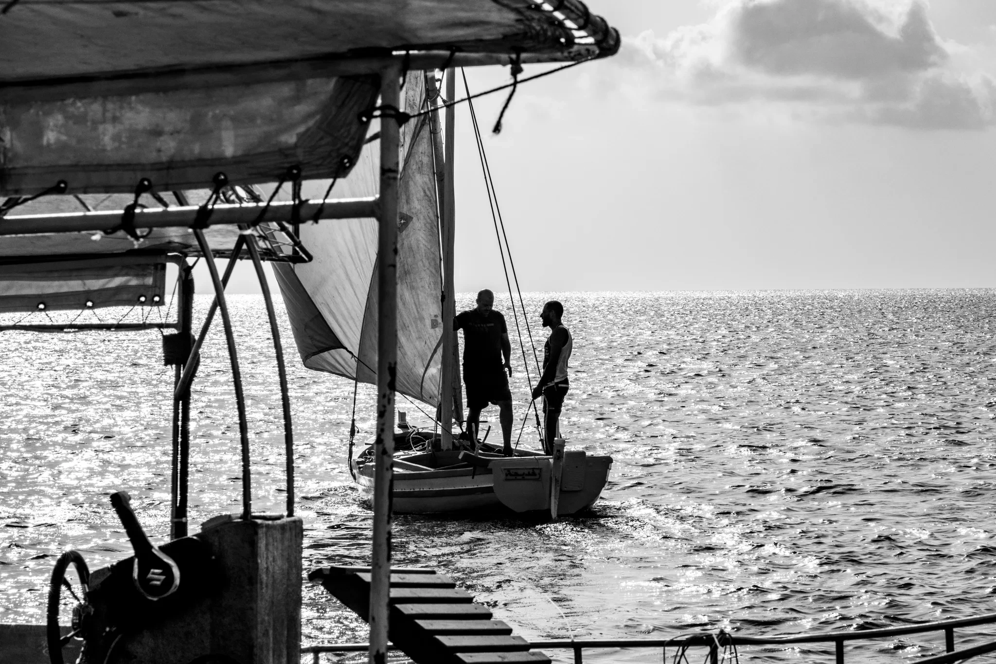 Personnes au bord de l’eau sous la structure d’un bateau