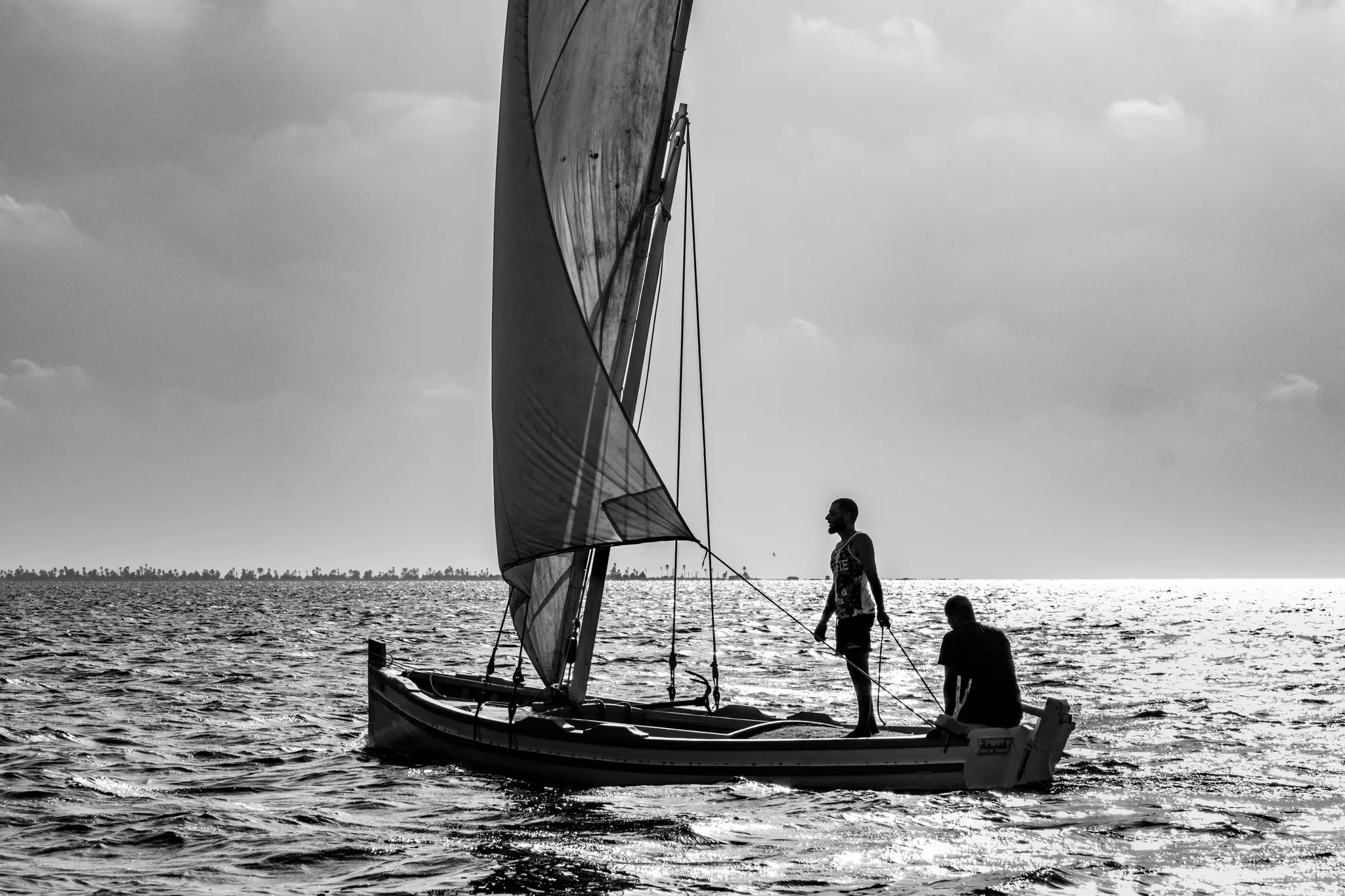 Personne debout à bord d’un bateau à voile latine