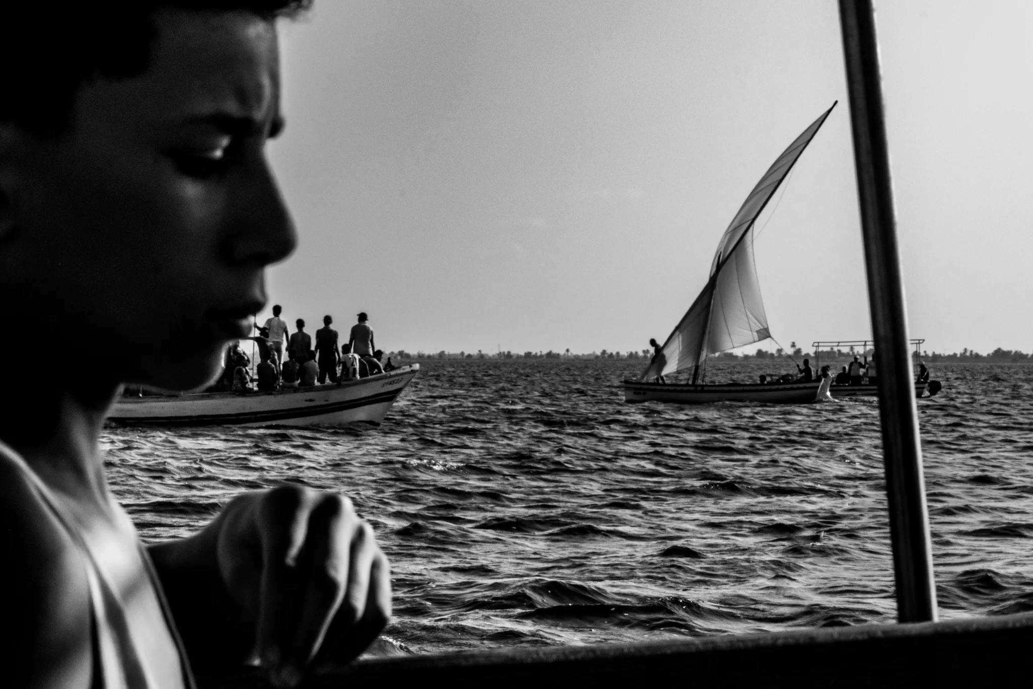 Profil d’un jeune près d’une embarcation à voile